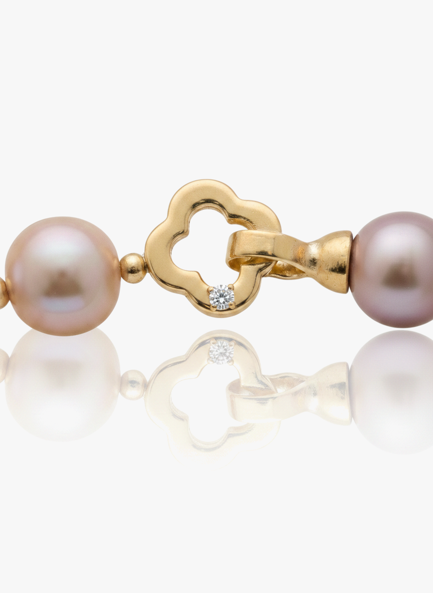 Pearl bracelet with gold clasp on a white background